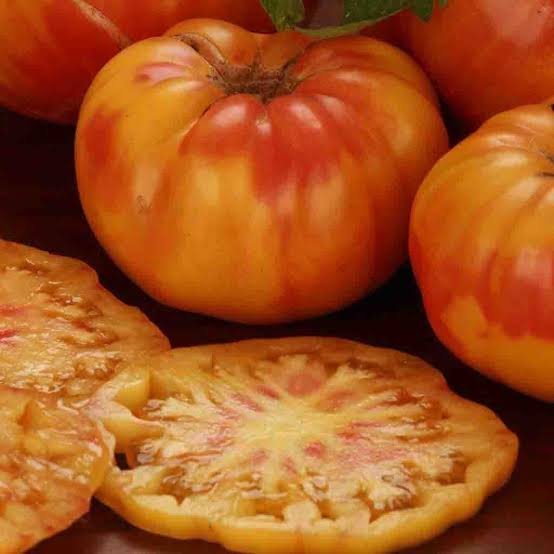 Big Rainbow Tomato Seeds for Planting producing large golden-yellow beefsteak tomatoes with beautiful red and orange marbled flesh