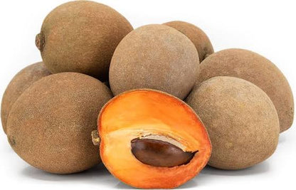 Fresh mamey sapote seeds and ripe tropical mamey fruits with rough brown skin and creamy reddish-orange flesh, showcasing a tropical fruit tree variety.