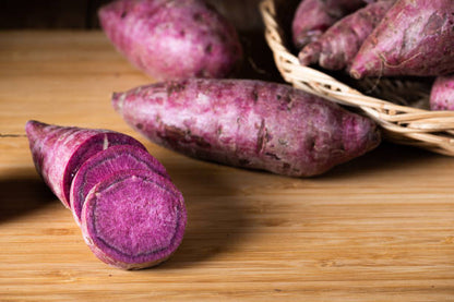 Purple sweet potato vegetable roots growing in a home garden