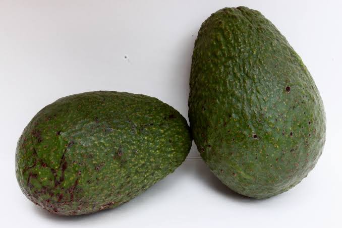 Fresh Sharwil avocado fruit with green skin and creamy flesh, showcasing the fruit variety for home garden growing.