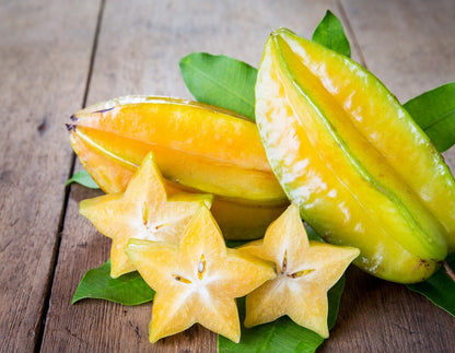 Star fruit seeds for planting to grow a tropical carambola fruit tree with lush green foliage and distinctive golden star-shaped fruits.